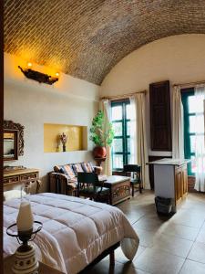 um quarto com uma cama grande e uma sala de estar em LA ERMITA "Antigua casa de Cantinflas" em San Miguel de Allende