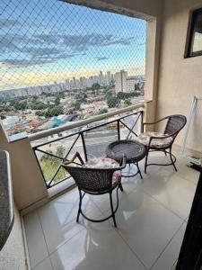 d'un balcon avec trois chaises et vue sur la ville. dans l'établissement Flat Apart Bristol Hotel Goiânia - Crystal Place, à Goiânia