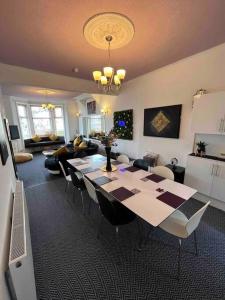 a living room with a table and chairs in a room at Winter Gardens large modern home in Blackpool