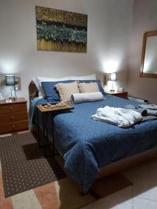 a bedroom with a blue bed with pillows on it at House by the sea/Σπίτι στην θάλασσα in Flámbouras