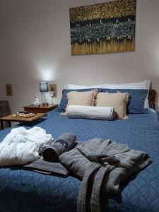 Un dormitorio con una cama azul con una manta. en House by the sea/Σπίτι στην θάλασσα, en Flámbouras