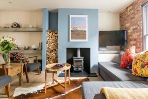 a living room with a couch and a fireplace at White Cottage in Whitstable