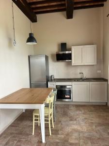 a kitchen with a wooden table and a refrigerator at Tenuta i 4 venti in Collesalvetti