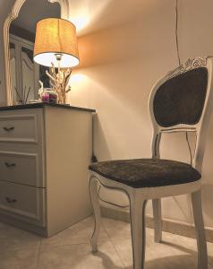 a chair sitting next to a dresser with a lamp at Flat 291 in Polignano a Mare