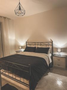 a bedroom with a black bed with two night stands at Flat 291 in Polignano a Mare