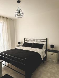 a bedroom with a black bed and a lamp at Flat 291 in Polignano a Mare