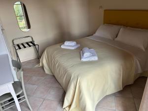 a bedroom with a bed with two towels on it at Tenuta i 4 venti in Collesalvetti