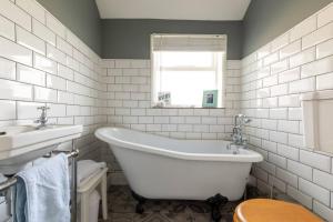a white bathroom with a tub and a sink at York House in Whitstable +28 photos