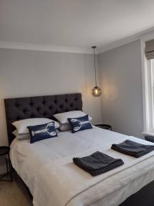 um quarto com uma cama grande e almofadas azuis e brancas em Eden Cottage em Whitstable