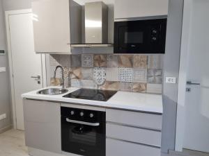 a white kitchen with a stove and a sink at Cà Fiamma 2 in Casale Monferrato