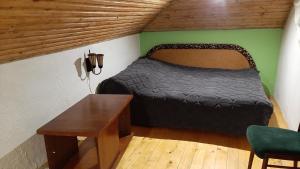 um quarto com uma cama e uma mesa num quarto em Затишок в Карпатах em Skole