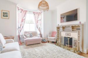 a living room with a fireplace and a chandelier at Goldfinch Cottage in Whitstable