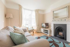 a living room with a couch and a fireplace at Jubilee Cottage in Whitstable