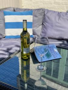 a bottle of wine and a glass on a table at Jubilee Cottage in Whitstable