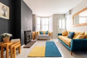 a living room with a couch and a fireplace at Fig Tree Cottage in Whitstable