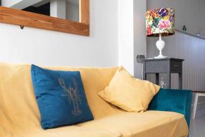 a couch with two pillows on it in a living room at Fig Tree Cottage in Whitstable