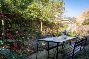 a table and two chairs in a garden at Fig Tree Cottage in Whitstable +7 photos