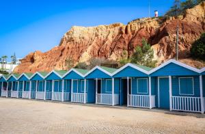 una fila de cabañas de playa azules frente a una montaña en Apartamentos Atlantico by OA en Albufeira