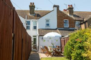 un patio con mesa y sombrilla en Furlong Place, en Whitstable