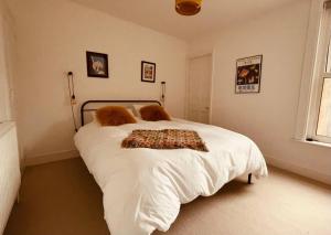 a bedroom with a large white bed with white sheets at Seal Cottage in Whitstable