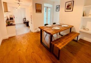 uma mesa de jantar e um banco numa sala de estar em Seal Cottage em Whitstable