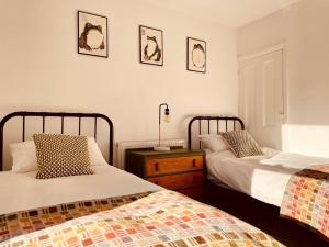 a bedroom with two beds and a night stand with two beds at Seal Cottage in Whitstable +9 photos