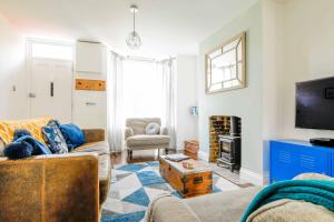 ein Wohnzimmer mit einem Sofa und einem TV in der Unterkunft Shell Cottage in Whitstable