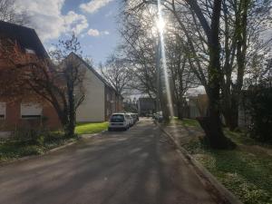 a street with cars parked on the side of the road at Duplex de standing in Anzin