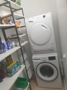 a washing machine in a room with a shelf at Duplex de standing in Anzin