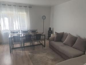 a living room with a couch and a table and chairs at Duplex de standing in Anzin