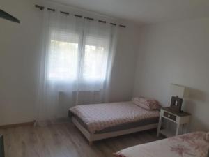 a bedroom with two beds and a window at Duplex de standing in Anzin