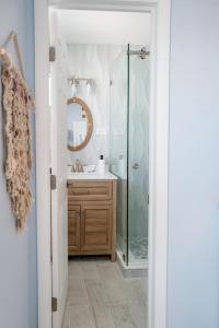 a bathroom with a shower and a sink and a mirror at Waterfront with Boat Lift/Kayaks and Hot Tub in Marathon