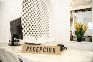 a reception desk with a sign that reads reception at Hotel Balneario de Marmolejo in Marmolejo +46 photos