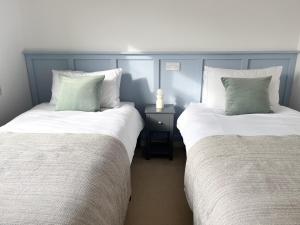 two beds sitting next to each other in a room at Peaceful Riverside Lodge in Christchurch
