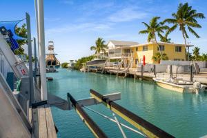 a boat is docked at a marina with houses at Waterfront with Boat Lift/Kayaks and Hot Tub in Marathon