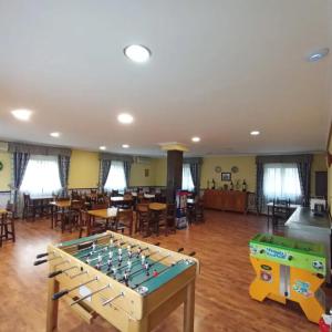 a room with a ping pong table and tables and chairs at HOSTAL RURAL ALTO TAJO POVEDA in Poveda de la Sierra