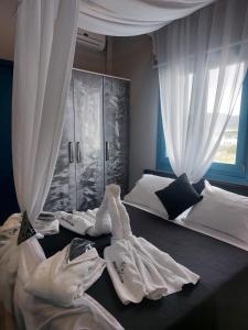 a bedroom with a bed with white sheets and curtains at George's point of view in Naousa