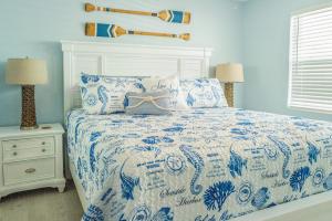 a bedroom with a blue and white bed with pillows at Waterfront with Boat Lift/Kayaks and Hot Tub in Marathon