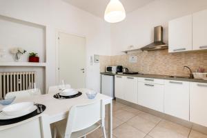 a kitchen with white cabinets and a white table and chairs at Deluxe Home Verona in Verona