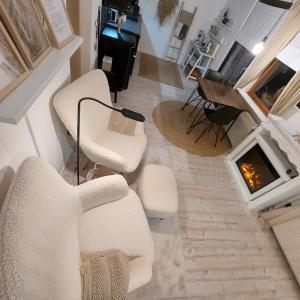 a living room with white chairs and a fireplace at Koje1 in Bremm