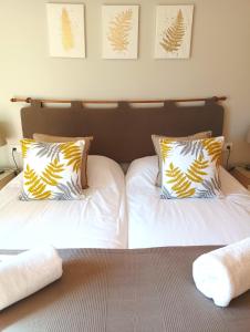 a bedroom with two beds with white sheets and pillows at Combarro Hills in Combarro