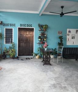 a blue room with a table and a ceiling fan at D GARDEN HOME STAY in Tanah Merah
