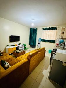ein Wohnzimmer mit einem großen Sofa und einem TV in der Unterkunft Nuna house in Nairobi