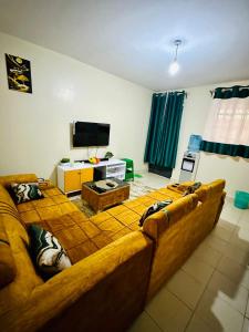 - un salon avec un grand canapé et une télévision dans l'établissement Nuna house, à Nairobi