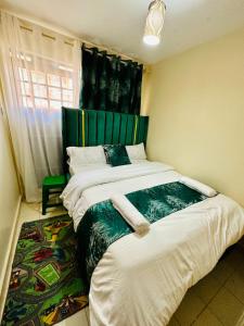 - une chambre avec un grand lit et une tête de lit verte dans l'établissement Nuna house, à Nairobi