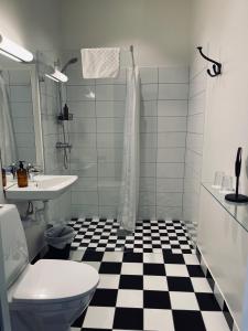 a bathroom with a black and white checkered floor at Stationen in Ystad