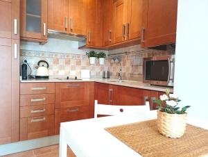 a kitchen with wooden cabinets and a table with a vase at Combarro Hills in Combarro