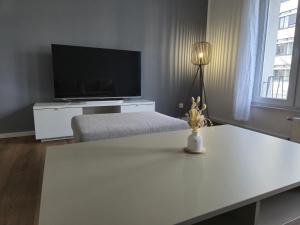 a living room with a television and a table with a lamp at Aus alt wird neu - Apartment in Essener City in Essen
