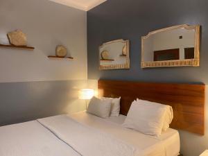 a bedroom with a bed with two mirrors on the wall at EZE Inn Boutique Hotel in Ezeiza