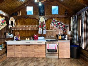 cocina con armarios de madera y horno con fogones en Casa Chindris, en Ocna Şugatag